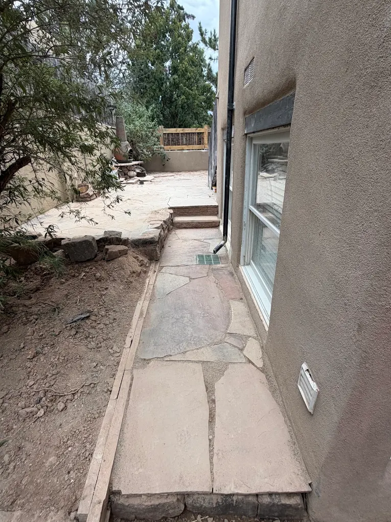 Finished flagstone walkway along the side of a home